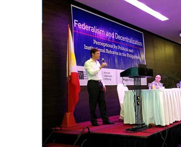 Man speaking into microphone at conference on Federalism and Decentralization in Philippines
