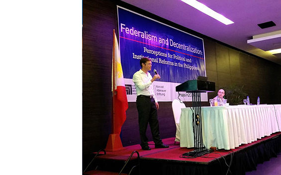 Man speaking into microphone at conference on Federalism and Decentralization in Philippines