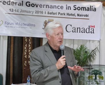 Bob Rae speaking into microphone during a conference on Federal Governance in Somalia
