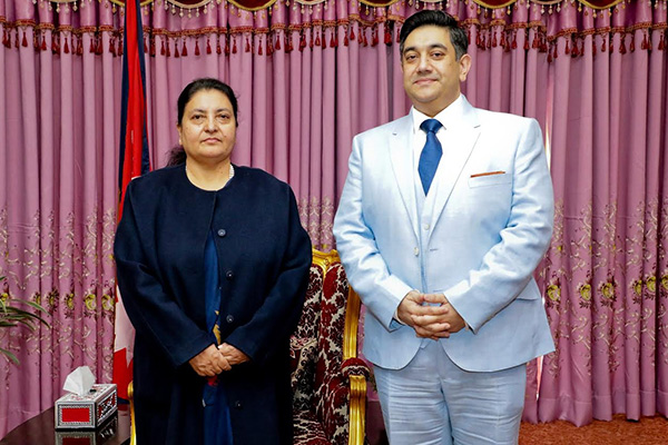 Two Nepalese officials posing in front of Canada flag